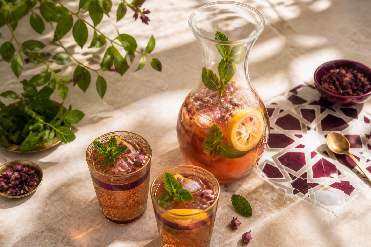 Iced herbal tea with lemon and fresh mint in Moroccan tea glasses